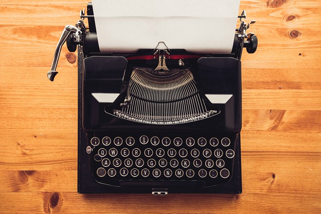 vintage-typewriter-machine-on-writers-desk-bcwvq2g-long.jpg