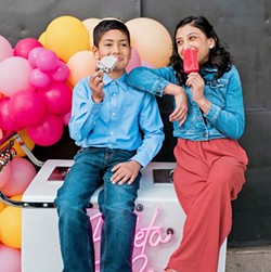 POPSICLE FUN (Left to right) Nolan Spears and Sophia Guzman enjoy a cold treat on top of the Paleta &amp; Co. ice cream cart. - PHOTO COURTESY OF STEFANIE ELIZABETH PHOTOGRAPHY