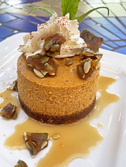 PUMPKIN PERFECTION Cinnamon whipped cream and brown butter caramel sauce complement Robin's Restaurant's seasonal pumpkin cheesecake. The pi&egrave;ce de r&eacute;sistance is its pepita brittle garnish (see recipe, below). - PHOTO COURTESY OF ROBIN'S RESTAURANT