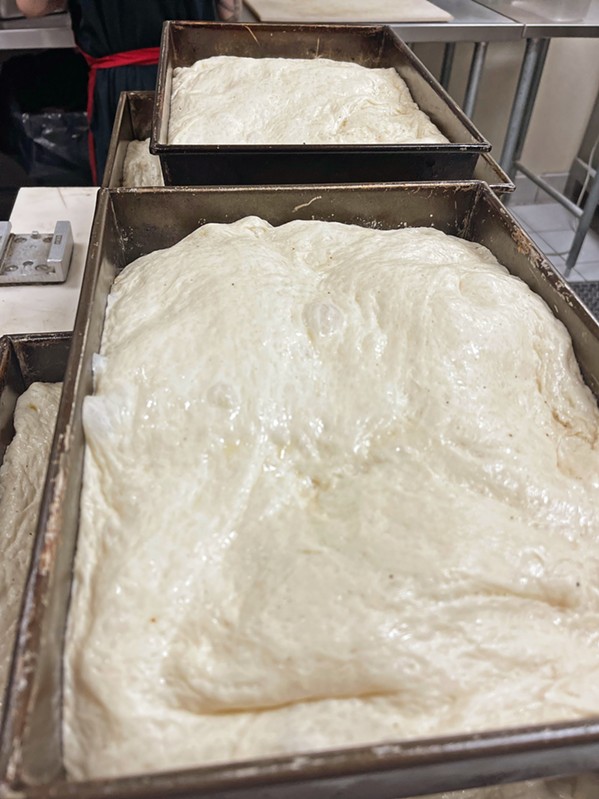 TWICE AS NICE Detroit-style dough is double-proofed. At Benny's Pizza, the first rise occurs in the dough pan, while the second rise occurs after the dough is de-gassed and flattened into oiled pizza pans. - PHOTO COURTESY OF BENNY'S PIZZA