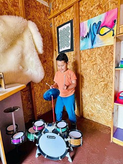 MAKING MUSIC A young Exploration Discovery Center patron makes some tunes in the Music Shed. - PHOTO COURTESY OF  EXPLORATION DISCOVERY CENTER
