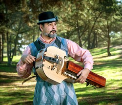 HURDY-GURDY MAN The cast members of As You Like It frequently find themselves singing or playing instruments, including guitars and accordions. But Touchstone's (George Walker, pictured) hand-cranked hurdy-gurdy is the most memorable. - COURTESY PHOTO BY LUIS ESCOBAR, REFLECTIONS PHOTOGRAPHY STUDIO