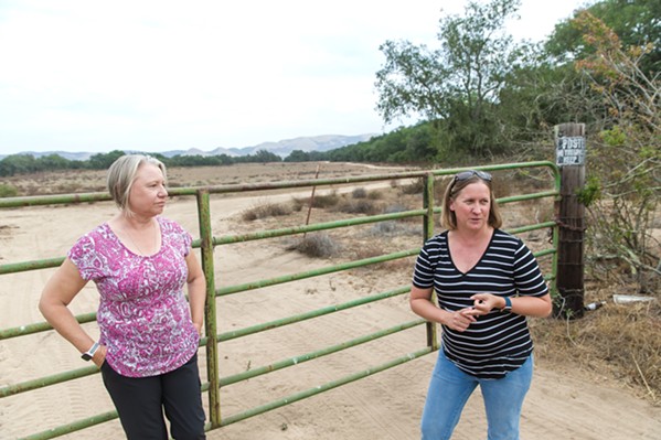 TALKING IMPACTS Backdropped by the site of the would-be Dana Reserve housing development with 1,289 proposed homes and units, Nipomo residents Alison Martinez (left) and Kelly Kephart explain why they oppose it. - PHOTO BY JAYSON MELLOM