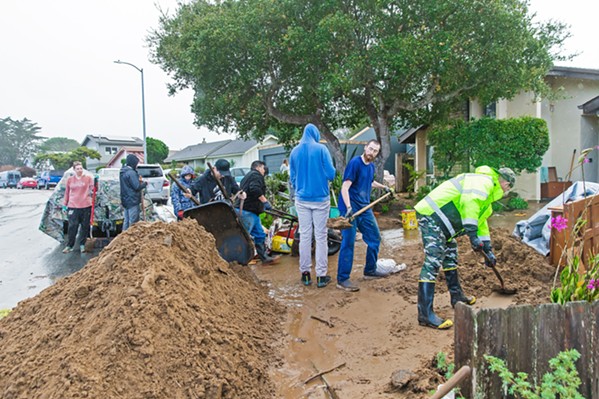 COMMUNITY HELP Hundreds of volunteers in Los Osos gathered to help residents on Vista Court dig out their homes from a mudslide caused when stormwater pushed through a Los Osos Community Services District water basin levee on Jan. 9. - PHOTO BY JAYSON MELLOM