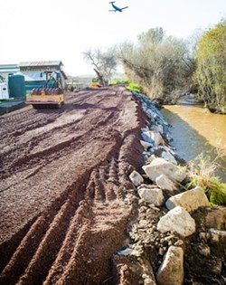FIXING A LEAK SLO County Public Works reinforces the Arroyo Grande Creek levee after it failed during an onslaught of storms in early January 2023. - PHOTO BY JAYSON MELLOM