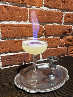 SIZZLING SIPS The craft cocktail menu at La Cosecha boasts signature and seasonal creations with local ingredients when available. Through the Looking Glass combines mezcal, key lime, orange Cura&ccedil;ao, and green Chartreuse. - PHOTO COURTESY OF LA COSECHA BAR + RESTAURANT