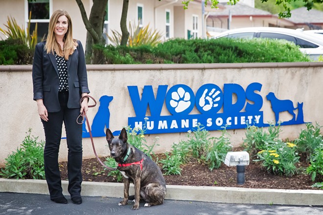 PET PROJECT Woods Humane Society CEO Emily L'Heureux, pictured with Harley, helms the Best Nonprofit Organization, which cares for more than 3,000 cats and dogs each year at its SLO and Atascadero facilities until they can be united with loving forever families. The organization, which began in 1955, offers low-cost spay and neuter services to other county animal rescue organizations as part of its goal to end pet overpopulation. - PHOTO BY JAYSON MELLOM