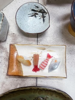 WITHOUT THE SOY SAUCE A unique white and gold plate with four kinds of glass sushi is the one and only for sale at Harmony Pottery Works. - PHOTO BY SAMANTHA HERRERA