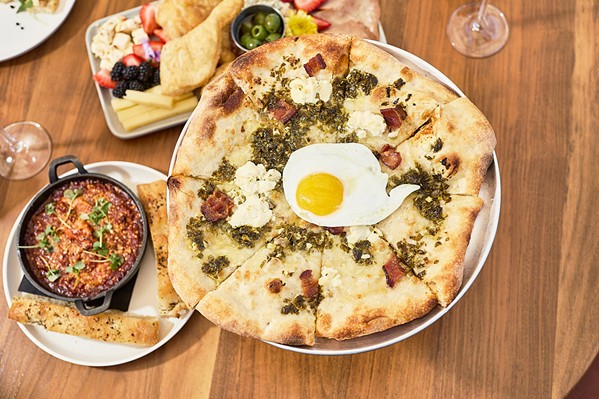 JUST ADD EGG Served as part of brunch on Saturdays and Sundays from 10 a.m. to 3 p.m., the Uovo Pizza comes with Cal Poly eggs, bacon, ricotta, and salsa verde. - PHOTO COURTESY OF NOMADA HOTEL GROUP