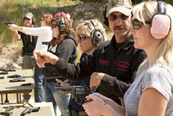 LINE UP :  Instructors John Marrs and John Odom teach safe gun techniques to (l-r) Suzanne Russell, Maeva Considine, Kelly Fontes, and Stephanie Ross. - PHOTO BY STEVE E MILLER