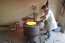 John Kemple prepares the furnace to begin pouring bronze. - PHOTO BY STEVE E. MILLER