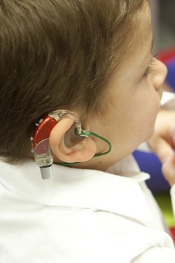 AMPLIFYING AID:  Preschooler Thomas&rsquo;s colorful hearing aid turns on a world of sound. - PHOTO BY STEVE E. MILLER