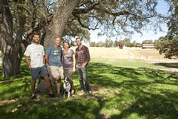 GRAPE MUSIC:  Over the shoulders of the Udsen family (Left to Right: Max, Niels, Bimmer, Luke, and Ruby the dog) lies the location of the stage for the Beaverstock music festival at Castoro Cellars. - PHOTO BY STEVE E. MILLER