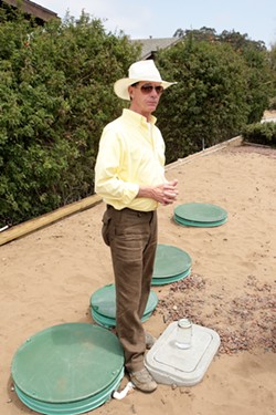 Tom Murphy, inventor of the Reclamator sewage recycling system, stands in front of the only installed system in Los Osos to date. - PHOTO BY STEVE E. MILLER