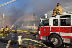 ASHES TO ASHES :  SLO firefighters worked for hours to put out an aggressive fire that gutted a popular novelty store on Higuera Street Dec. 26. The cause of the blaze has not yet been determined. - PHOTO BY DYLAN HONEA-BAUMANN