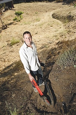 GRAYWATER TO GARDEN :  Mikel Robertson has installed a legal graywater system to irrigate a future orchard on his rural property. The $180 county permit he bought for the system will no longer be required after Aug. 4. - PHOTO BY STEVE E. MILLER