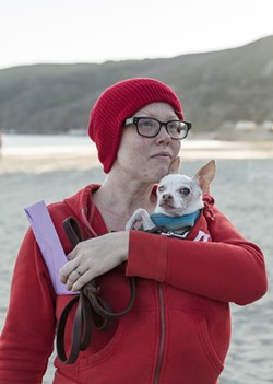 LIFE AQUATIC, AND CANINE:  Newlywed Aileen Manley, wearing the red beanie that has become the trademark of this ridiculous event, protected her love Taco from the elements. - PHOTO BY COLIN RIGLEY