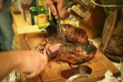 MEATFEST :  Ted Thayer had carving duty, slicing up two turkeys, two tri-tips (pictured), and two pork loins. - PHOTO BY GLEN STARKEY