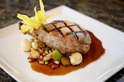 PLUMP PIGS:  On the dinner menu, one can order this grilled Berkshire pork chop with grilled corn succotash and red eye gravy. - PHOTO BY STEVE E. MILLER