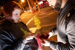KNIT TAGGERS :  Neal Breton and Adriana Hernandez tag downtown SLO with colorful knitted squares on June 24. - PHOTO BY STEVE E. MILLER