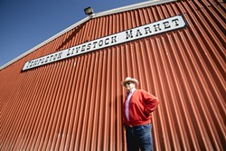 THE BIG RED BARN:  Dick Nock stands before the Templeton Livestock Market in February. - PHOTO BY TOM FALCONER
