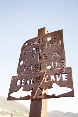 DON'T BE A LITTERBUG :  A handmade sign above the cove offers directions, as well as a little insight into local customs. The beach functions almost without incident, and is maintained by the efforts of its regular sunbathers. - PHOTO BY STEVE E. MILLER