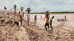 CHANGING WITH THE TIMES:  Workers in Bangladesh build up embankments and make the river bed lower in response to climate change raising sea levels in the digital composite image 'Building Up The Embankment Along The Kholpetua River' by Carrie and Eric Tomberlin. On average, images in the couple&rsquo;s series on climate change are a product of about 70 different photos fused together to give the viewer a broader understanding. - PHOTO COURTESY OF CARRIE AND ERIC TOMBERLIN