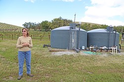 TANKED:  Sue Luft stands beside her water tank while talking about why a water district was the best choice to manage the Paso basin. - PHOTO BY DYLAN HONEA-BAUMANN