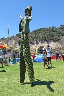 DOWN THE RABBIT HOLE:  The Mad Hatter moves through the crowd on stilts during the Central Coast Oyster and Music Fest on July 9. - PHOTO BY GLEN STARKEY