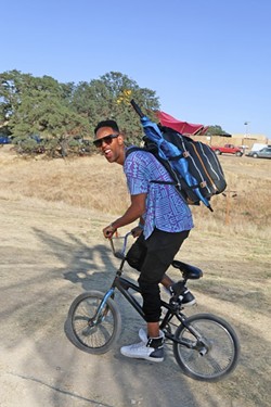 FAMOUS AMONG THE CROWD :  One of the main stage performers at LIB this year, Lafa Taylor, is one of the smart ones who brought his bike to get around the vast space that the festival is held on. - PHOTO BY DYLAN HONEA-BAUMANN