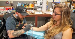 NO MUD, NO LOTUS:  New Times Arts Editor Ryah Cooley&rsquo;s sneaks a peek while Nik Blakhart of Sink or Swim Tattoo in Grover Beach works on a lotus flower design on her wrist. - PHOTO COURTESY OF RYAH COOLEY