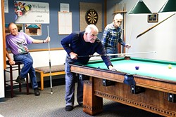 OUT AND ABOUT:  Regulars at the 100-year-old pool table in the Morro Bay Senior Center are left to right: Wayne Gillmore, 79, Peter Gabriel, 66, and Rey Hudson, 85. They play pool for about three hours every day. Centers like this one help provide opportunities for SLO County seniors to stay active and engaged in their community. - PHOTO BY JAYSON MELLOM