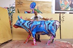 A COW OF A DIFFERENT COLOR:  Artist Man One stands with a cow he painted for the public art show, COWABUNGA, in Dana Point, Calif. Man One will paint another cow live for the Cow Parade in SLO on Sept. 17. - PHOTO COURTESY OF MAN ONE
