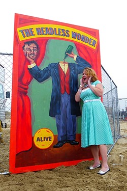 PRETTY AS A CARNIVAL PICTURE:  Anna Starkey got all dolled up in &rsquo;40s garb, posing here with one of the many props scattered along the beach raceway. - PHOTO BY GLEN STARKEY