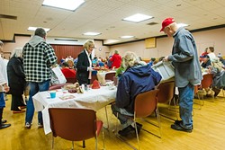 CHRISTMAS CHEER:  Morro Bay City Council members Robert Davis (right) and Marlys McPherson (center) give out hats and cookies to attendees at a community dinner in Morro Bay the week of Christmas. - PHOTO BY JAYSON MELLOM