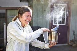 CAN WE BEE FRIENDS?:  A smoker subdues the bees as Lindsey Morgan pulls frames from her single hive located in her Morro Bay backyard. The amateur beekeeper swears the colony mysteriously &ldquo;found her.&rdquo; - PHOTO BY JAYSON MELLOM