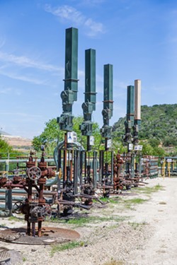 TECHNOLOGICAL ADVANCE Linear rod pumps like these are dispersed among old style pump-jacks on the Arroyo Grande oil field. - PHOTO BY JAYSON MELLOM