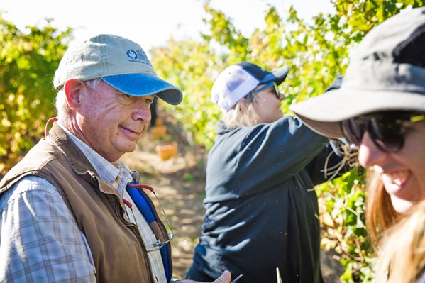FIELDWORK Ric Fuller (left), head of Allan Hancock College's viticulture operations, takes a break during the Oct. 25 harvest at the Santa Maria campus vineyard. Students work harvests either as volunteers or as part of their viticulture classes. - PHOTO BY JAYSON MELLOM