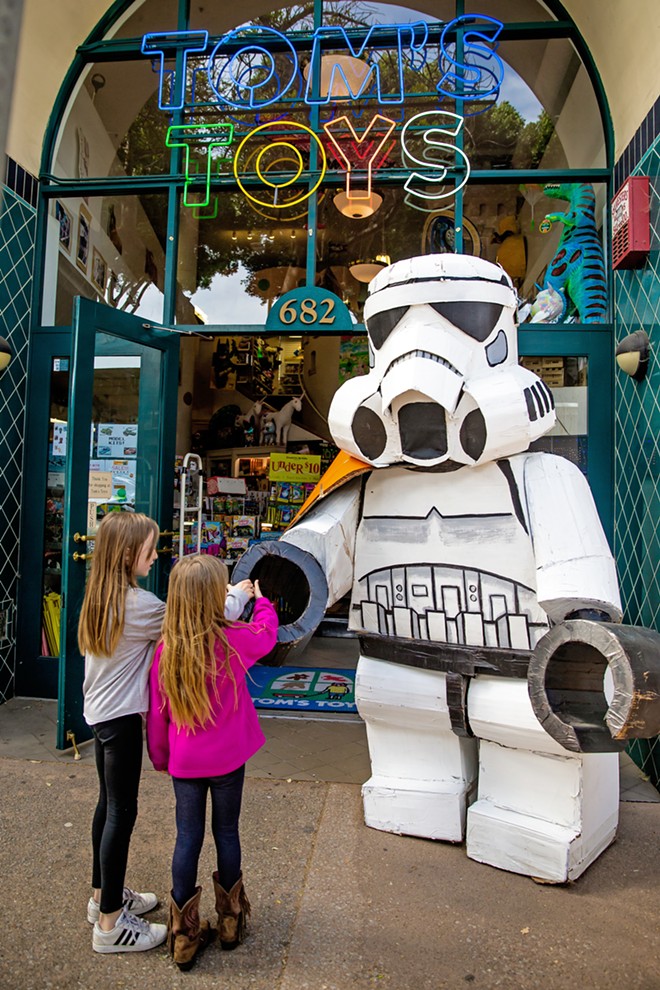 DARTH SIGHTING Charlotte Petit, 10, and Maddie Petit, 8, shake hands with the dark side at Tom’s Toys, aka the Best Toy Store ever. - PHOTO BY JAYSON MELLOM