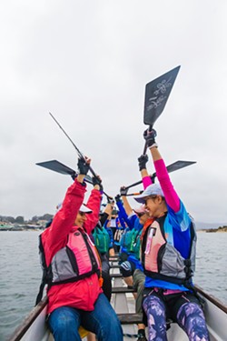 CAMARADERIE Paddlers celebrate after completing a dragon boat practice race in Morro Bay on Sept. 28. - PHOTO BY JAYSON MELLOM