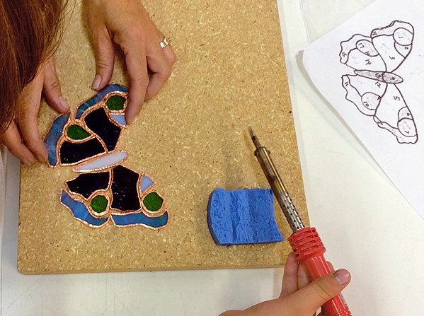 TAKE FLIGHT A class participant at Glasshead Studio makes a mosaic butterfly. - PHOTO COURTESY OF LISA REN&Eacute;E FALK