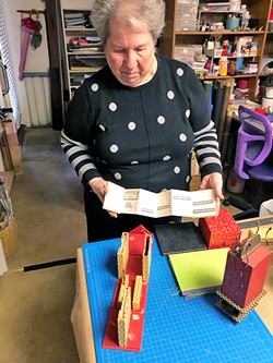 SURPRISE INSIDE Meryl Perloff shows one of her accordion-style books while standing in her home studio in San Luis Obispo. - PHOTO BY MALEA MARTIN