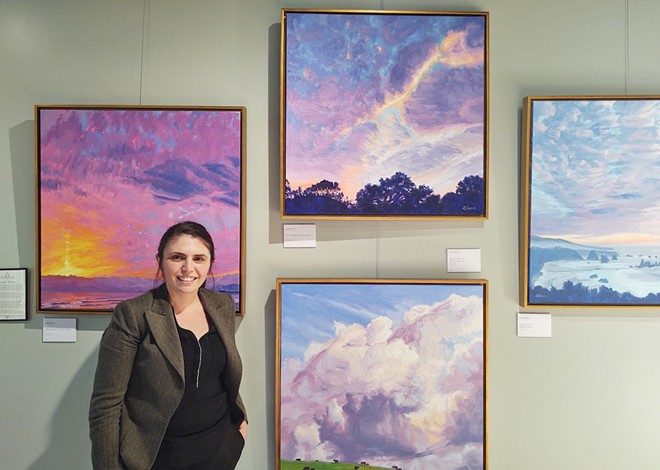 COLORFUL CURATION Alongside museum-quality prints by historic artists, Solvang Fine Art also showcases a selection of local contemporary artists as well. Pictured: gallery owner Julie Torchia in front of a display of paintings by Arroyo Grande-based artist Laurel Sherrie.