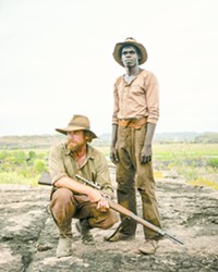 MORAL QUANDARY Travis (Simon Baker, left) and Gutjuk (Jacob Junior Nayinggul) team up to hunt down Gutjuk’s uncle, who’s leading a mob that’s attacking white settlements in early 1930s Australian outback, in High Ground, screening on Hulu.