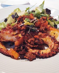TASTY TENTACLES The grilled octopus is a crowd favorite that arrives smoky and red, paired with crispy chorizo and a lightly dressed mixed salad.