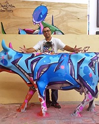 BIG COW, LITTLE COW: YOUNG LOCAL ARTIST WORKS ALONGSIDE HERO MAN ONE AT COW PARADE