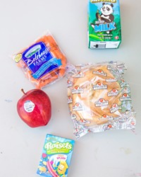 NOT SO STANDARD Participants of the summer meal program can count on not only a snack in their white paper sack but an apple, carrots, a sandwich, and milk.