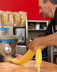 FLOUR ON HIS HANDS Lloyd Herrera guides freshly made linguine through a state-of-the art imported Italian pasta machine at Etto in Paso Robles' Tin City.