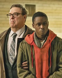 ENSLAVEMENT Ten years into an alien occupation, collaborator Officer Mulligan (John Goodman, left) believes Gabriel (Ashton Sanders), a young man whose brother was part of the alien resistance, may be a threat to his alien masters.