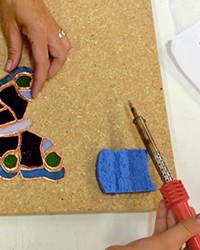 TAKE FLIGHT A class participant at Glasshead Studio makes a mosaic butterfly.